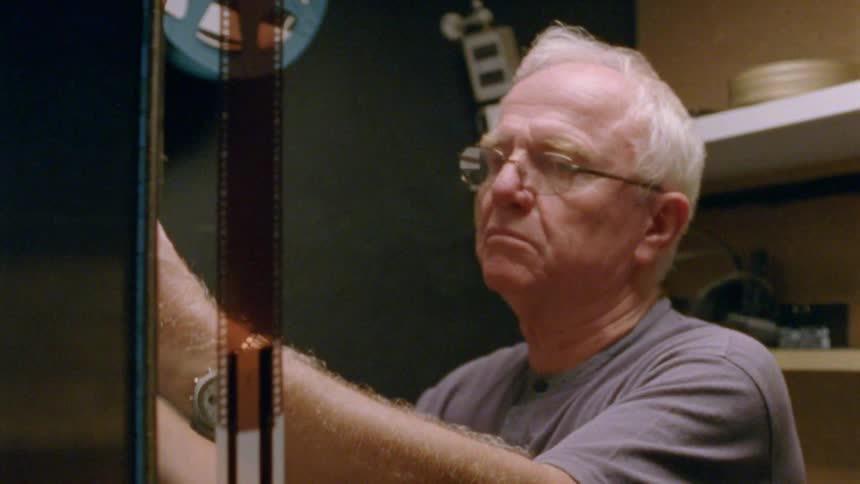 A man looking at film in a room