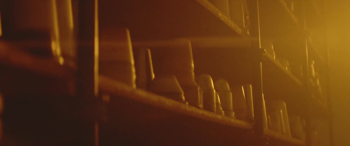 A room with shelves of pottery with a wall in the background