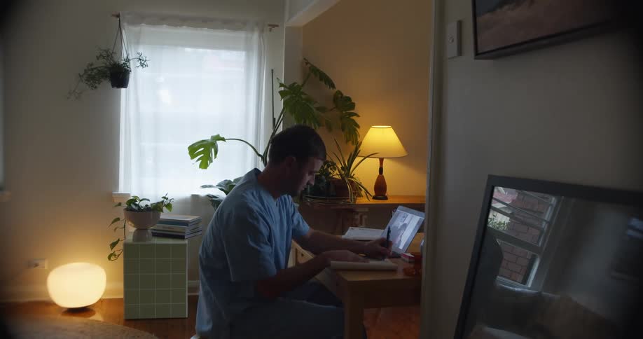 Young male nurse working on a laptop from home