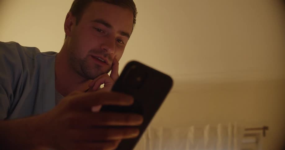 A man looking at a smartphone in a room