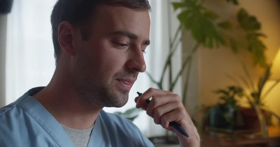 Young male nurse working from home talking on a call