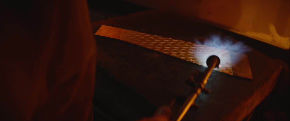 A blacksmith is heating metal with a torch