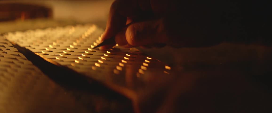 A person in a room using a tool on a piece of metal