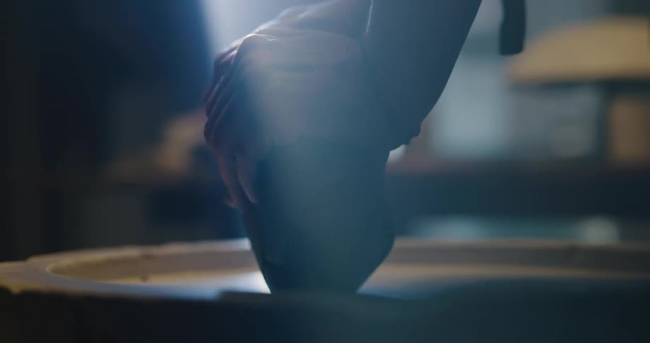 A woman kneading clay indoors
