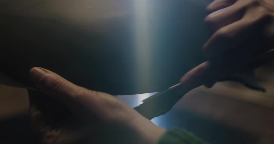 A person in a room shaping clay into pottery with a stick