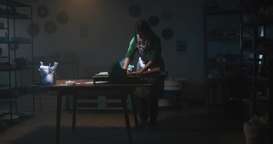 A woman working on some clay she is sculpting
