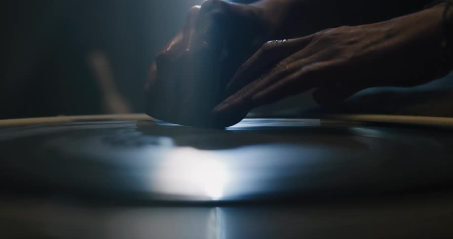 A person in a room shaping clay on a spinning wheel