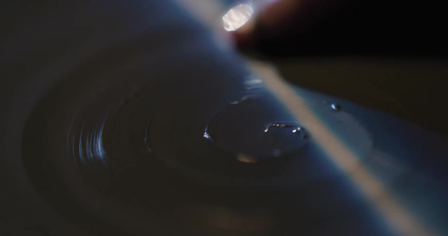 A person in a room shaping clay on a spinning wheel