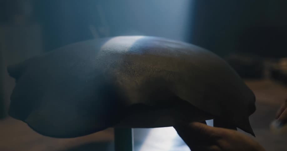 A person working on clay with a sponge