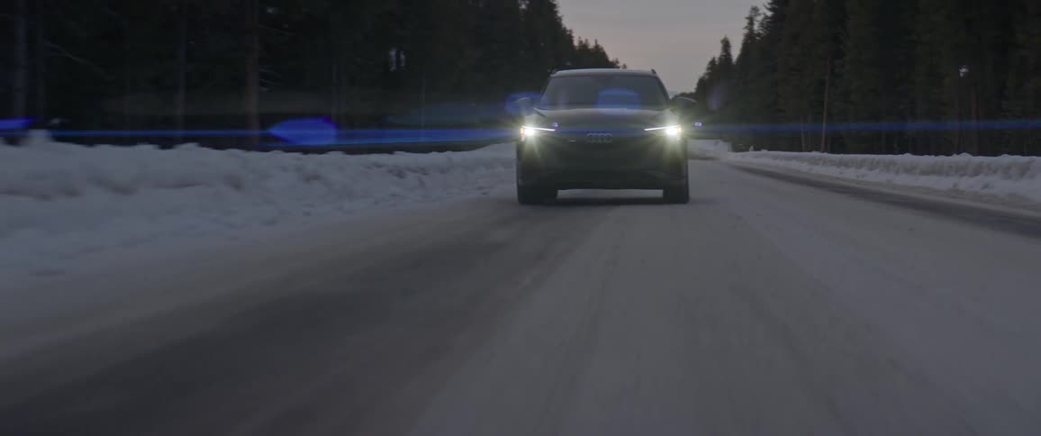 Black sports car driving on a snow covered road in the countryside