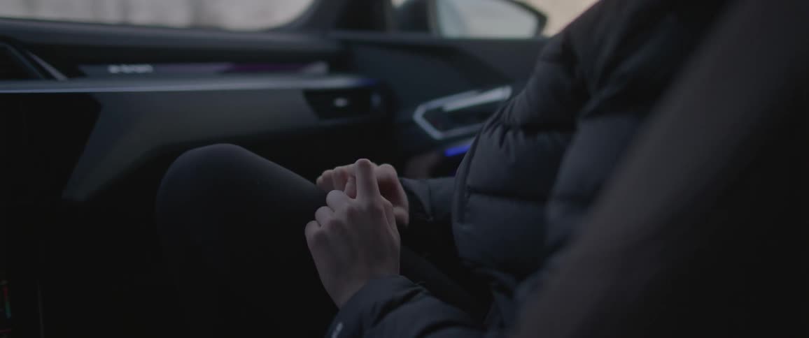 A person with a coat sitting in a vehicle