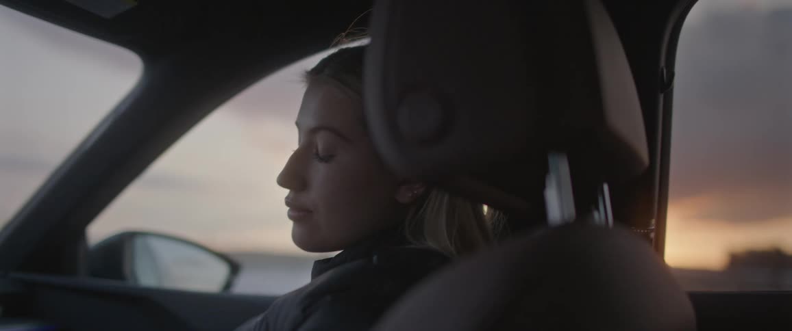 A female passenger rides in an automobile while glancing over towards the driver
