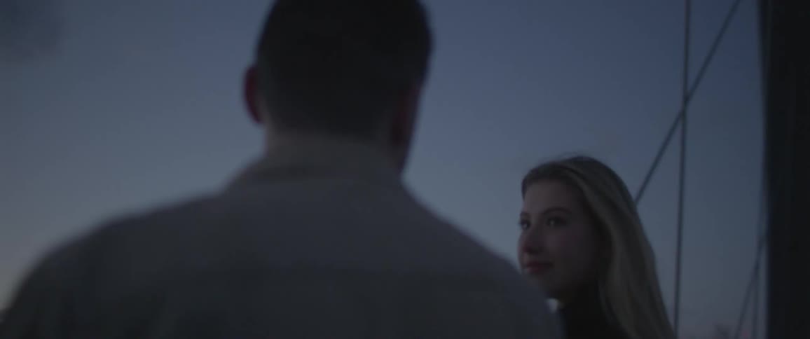 A woman smilingly looks at a man who seems to be saying something to her