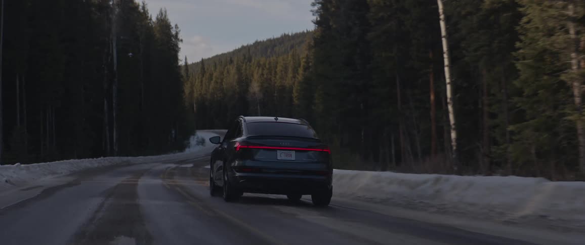 A car that is driving down the road on a snowy day
