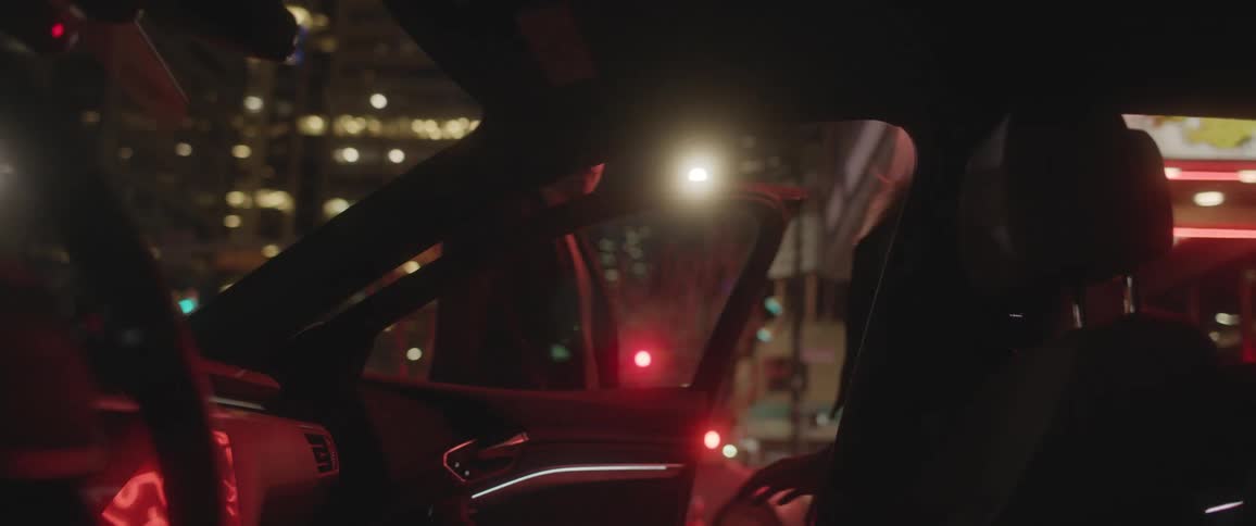 A man walks up to a car and opens the door for a woman who gets in