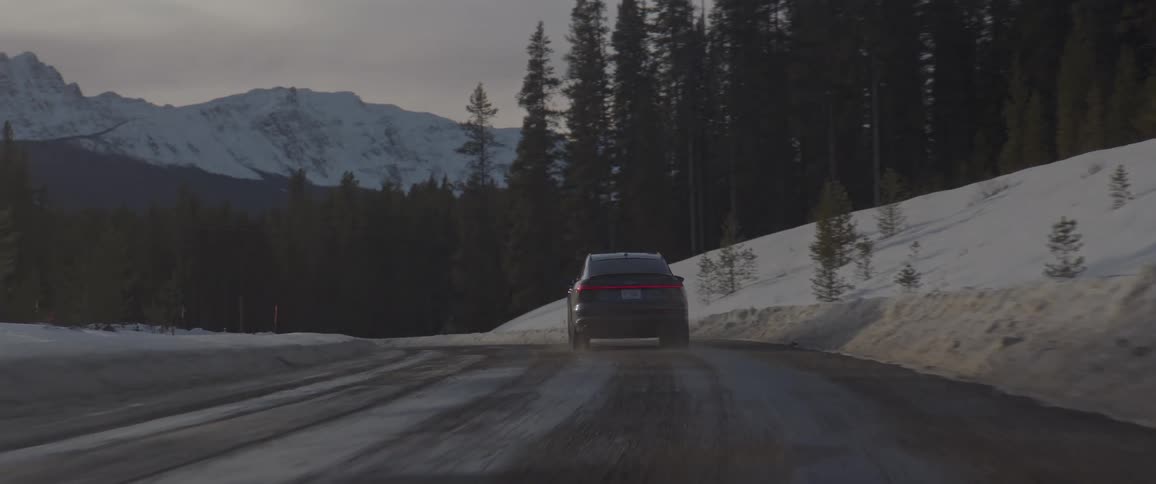 Black sports car driving on a rural road in the forest at morning
