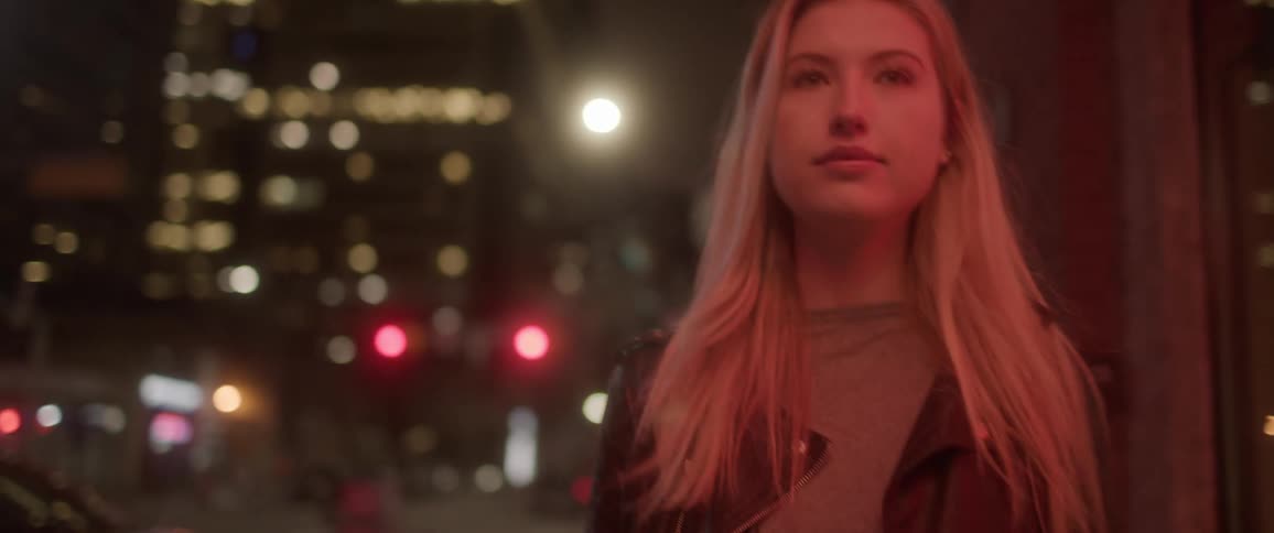 A woman walking in a big city at night
