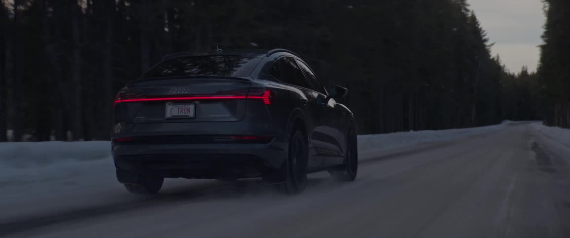 Black sports car driving on a rural road in the forest at morning