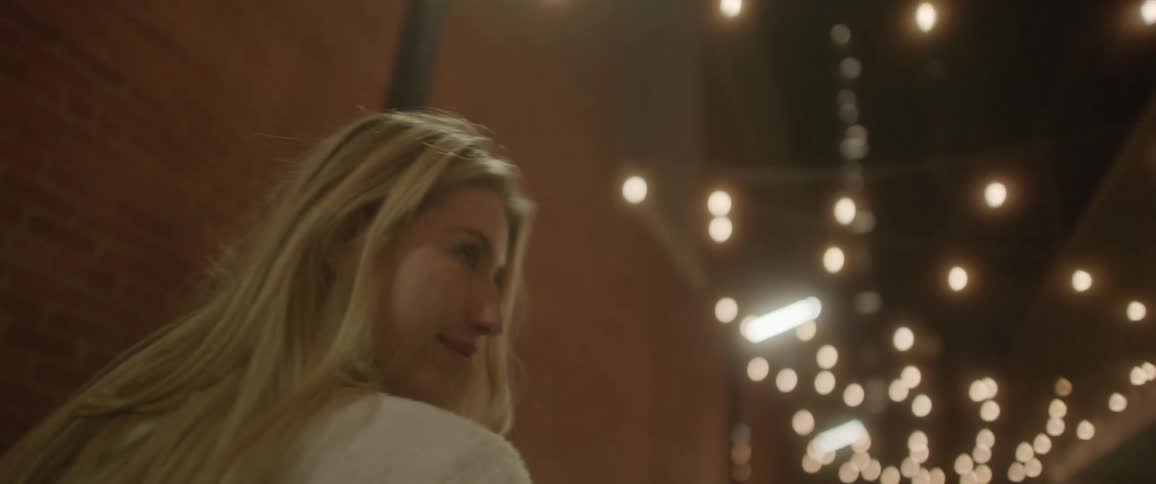 A man and woman walk down the alley together