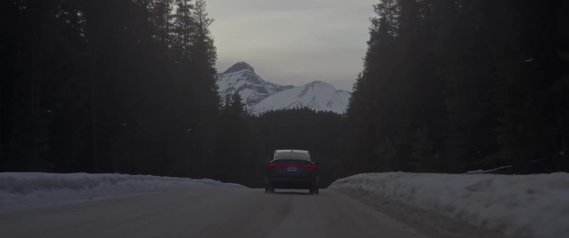 A car drives on a road towards the mountains