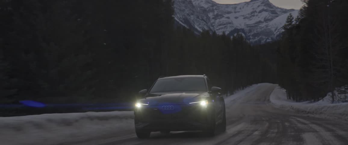 Black sports car driving on a rural road in the forest near the mountains at morning