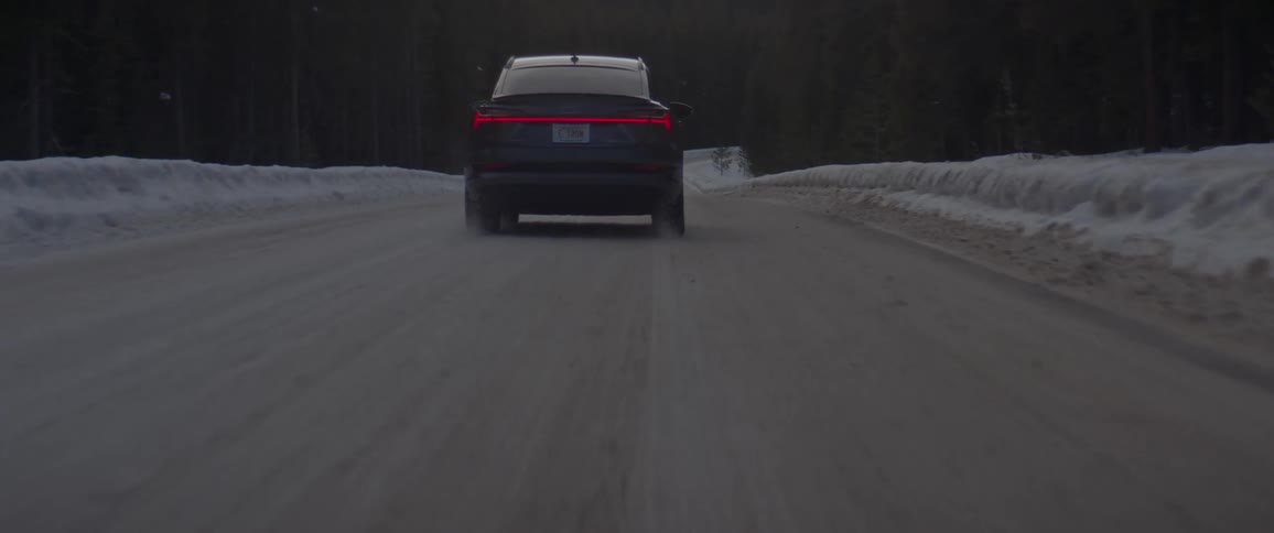 A car is driving on a road in winter