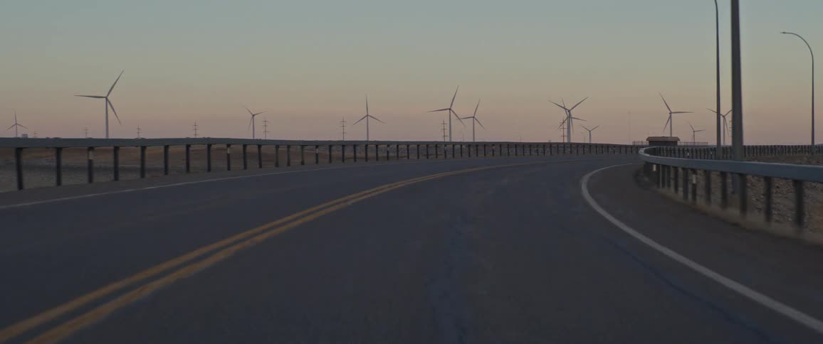 Driving on the road with shot of wind turbines