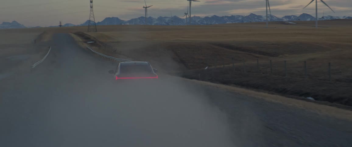 A vehicle drives a rural road and kicks up a lot of dust behind it