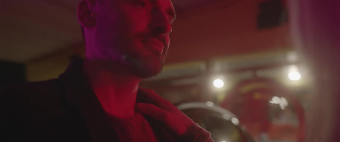 A woman runs her hand up her boyfriends chest as they dance in a club