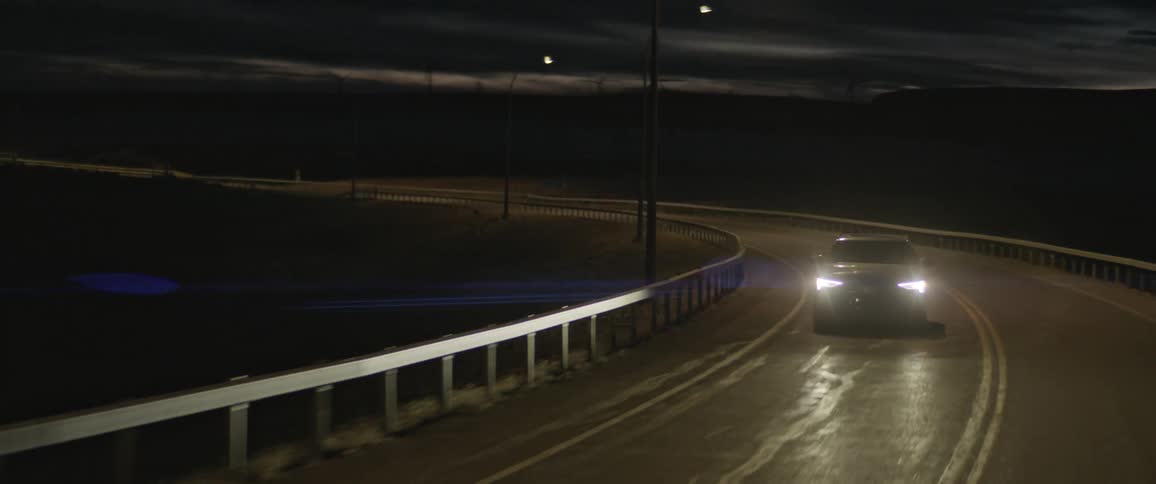 Dark grey audi car drives on highway at night