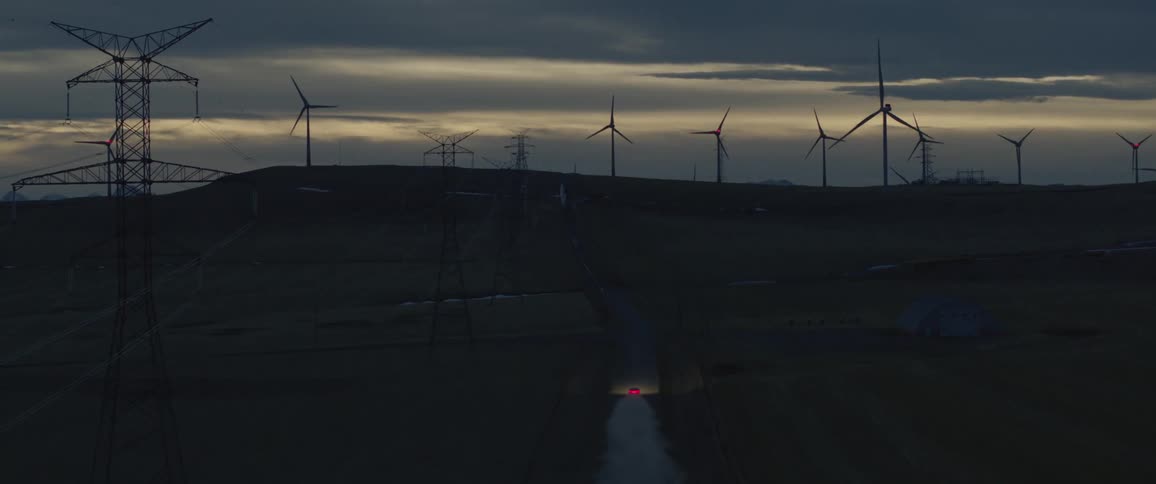 A car is driving through the country at dusk