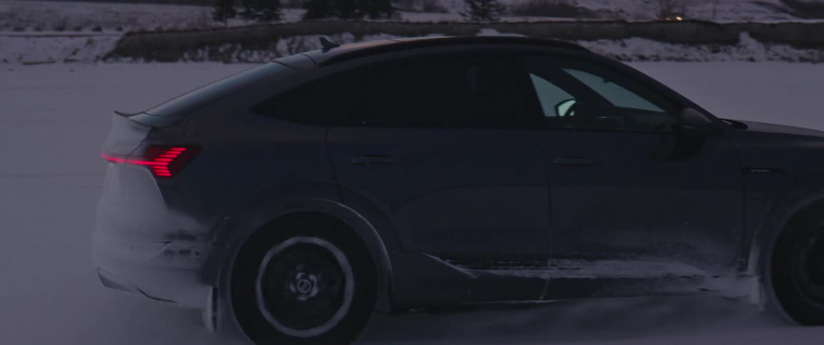 A car is driving on a road in winter