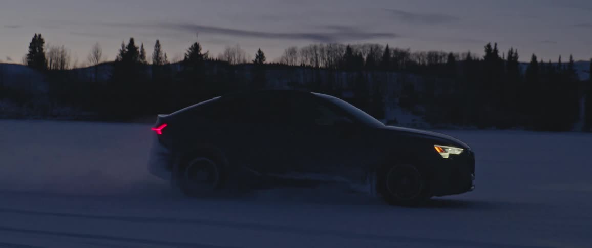 A vehicle swerves and loses control as it drives through a snowy field at night