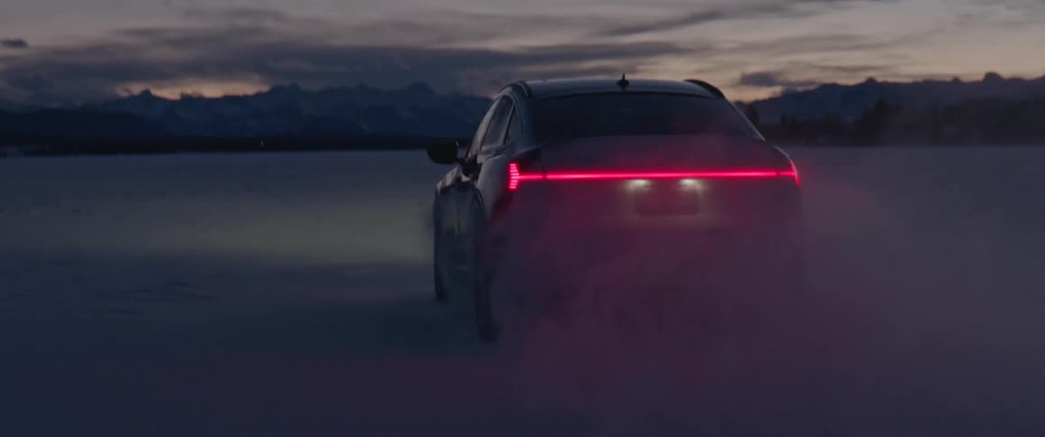 Audi car drives and puts on brakes in the field at dusk