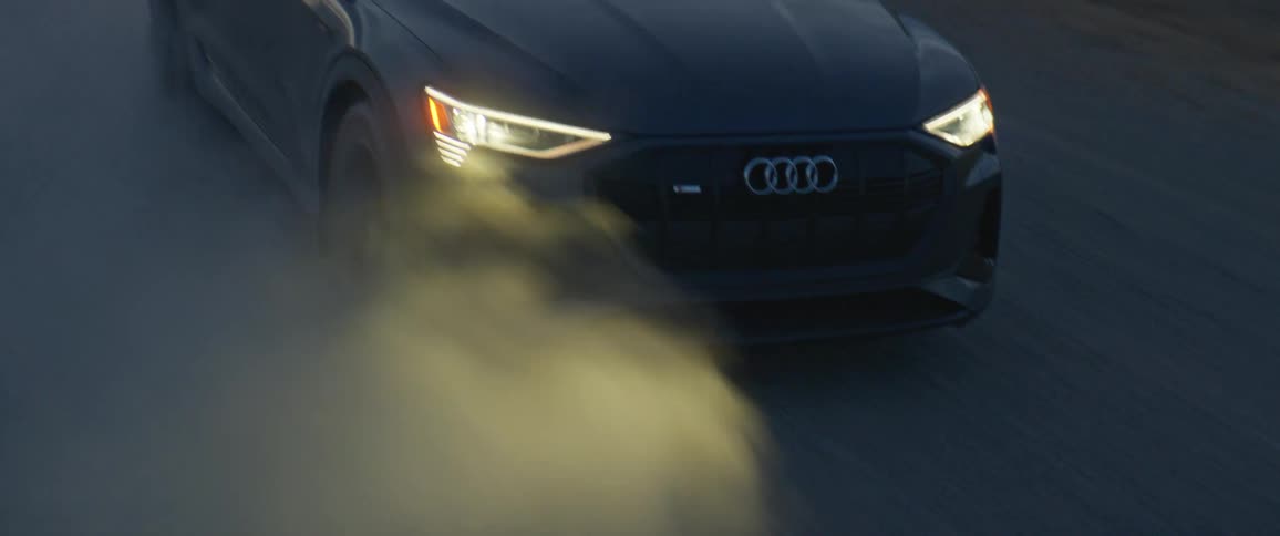 A vehicle with headlights driving on a road with smoke