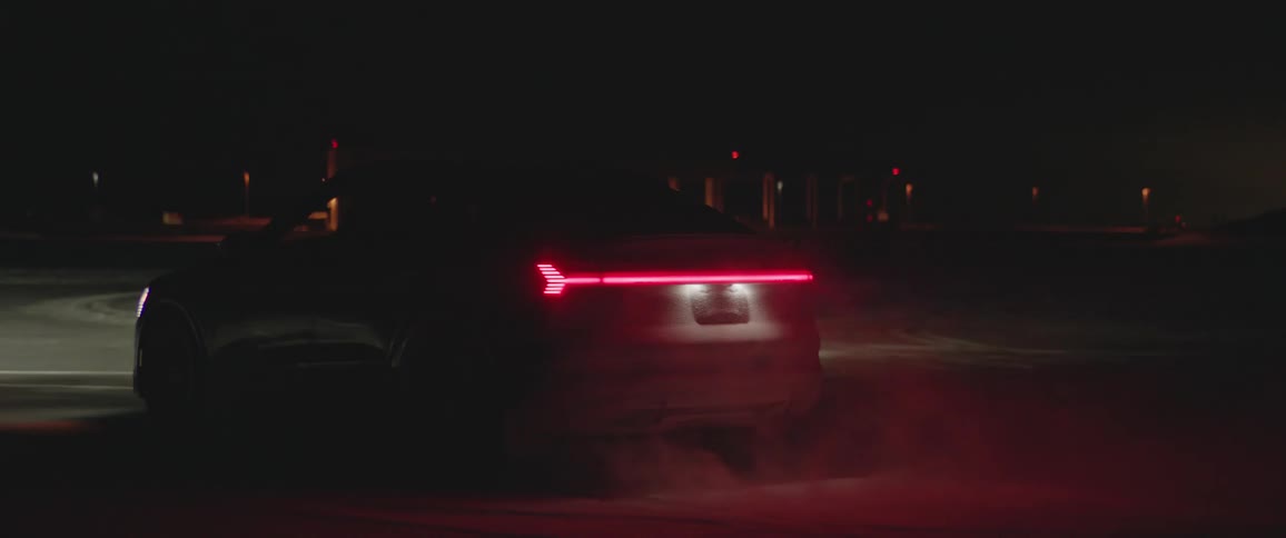 A car is driving on a road at night in winter