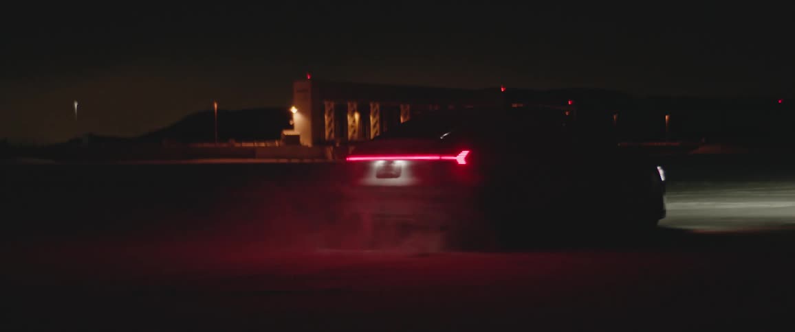 Black sports car driving on the snow covered plains in the countryside at night