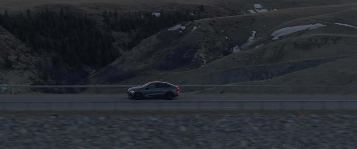 Car driving on a road near the wind turbines at evening