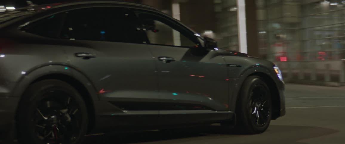 Black sports car driving on the city streets at night