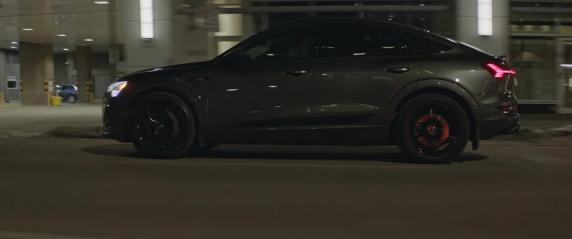 A vehicle driving on a city road with buildings in the background