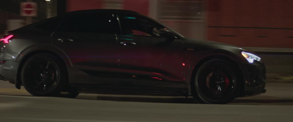Dark grey audi car travels in the city street at night