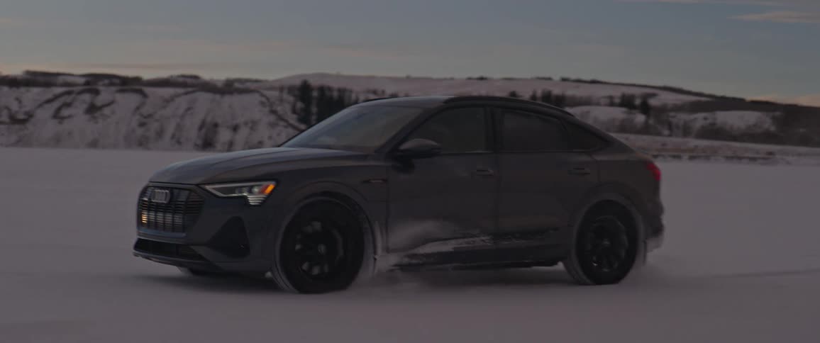 Sports car driving on the white sands of a desert at evening