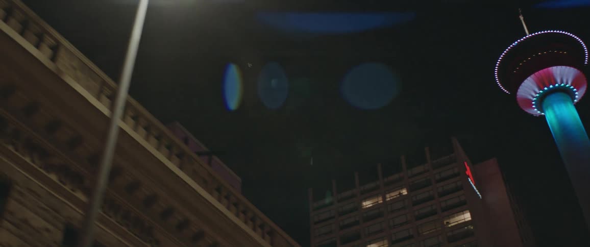A city with buildings with windows and lights with the sky in the background