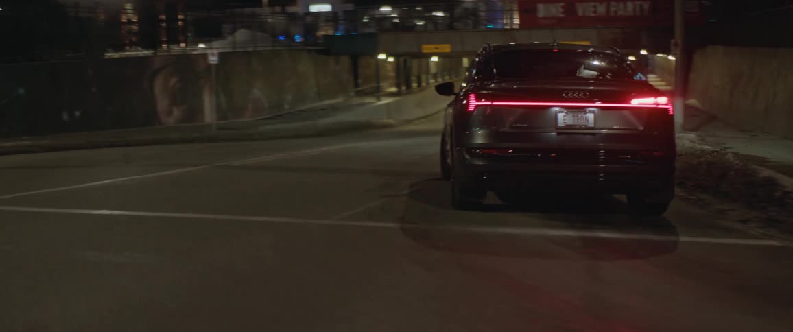Black sports car driving on the city streets at night