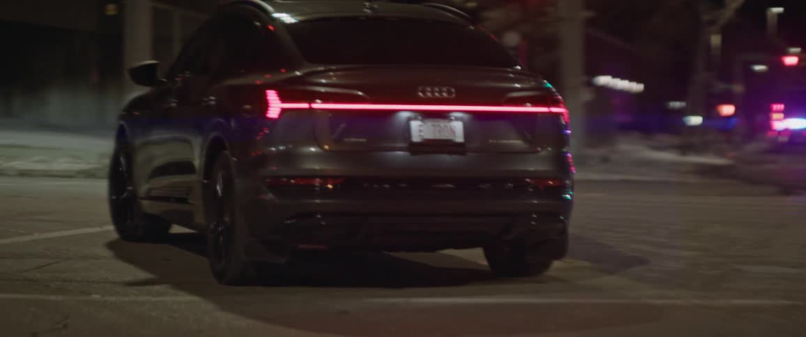 A vehicle makes a left turn on a city road at night