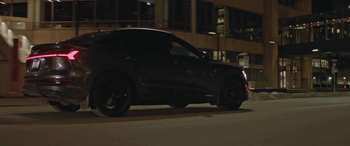 A vehicle drives a city road at night