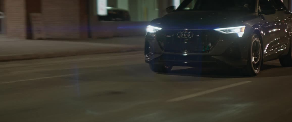 Audi car drives on asphalt city road at night
