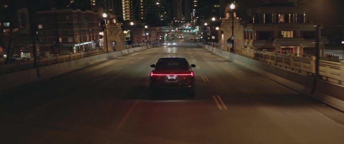 A vehicle driving on a city road with buildings in the background