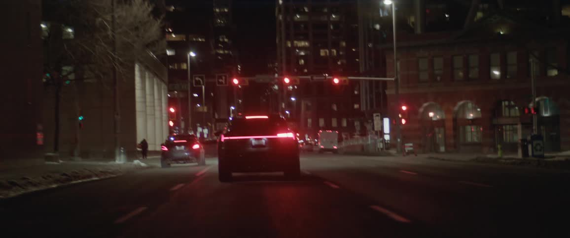 A car is driving on a road in a downtown city