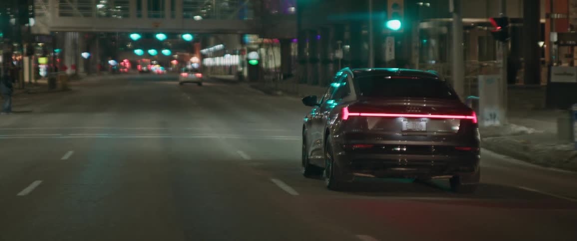 Black car driving on the city streets at night